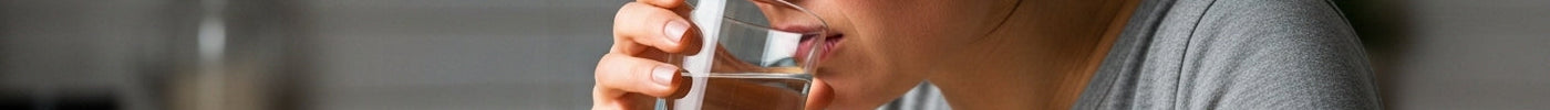 a woman suffering from acid reflux and drinking alkaline water to help with the pain